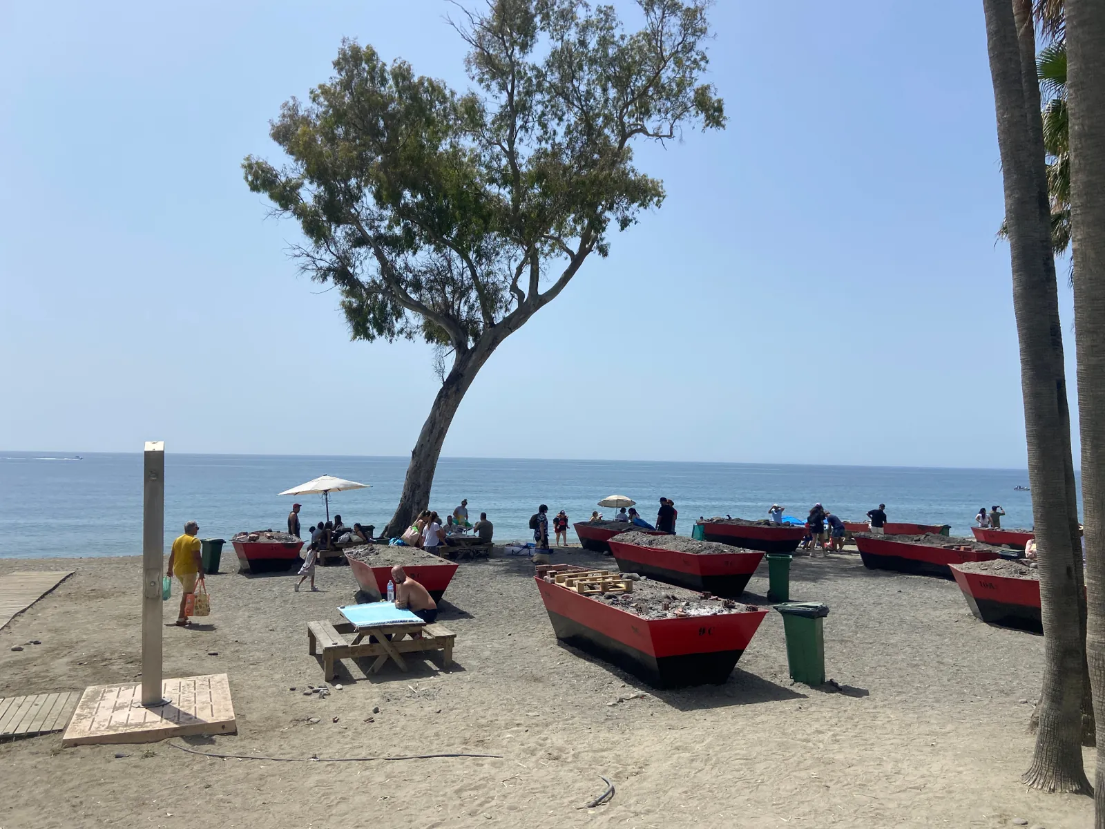 Relaxed sandy beach in San Pedro de Alcántara with traditional espeto boats and the Mediterranean